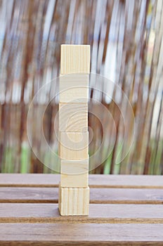 Selective focus shot of the wooden toy cubes on top of each other on a wooden surface