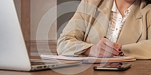 Selective focus shot of a young businesswoman writing in her notepad