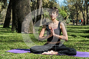 Selective focus shot of a young Caucasian female doing yoga practice in the park