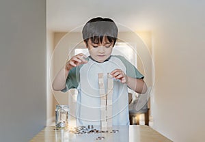 Selective focus smart kid building the tower stack from wooden blocks toy Happy Child boy playing stack of wood cube in living