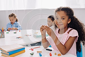 selective focus of smiling african american kid with plasticine