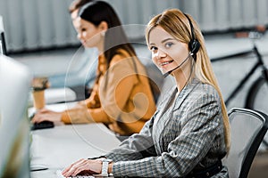 Selective focus of smiling call center operator looking at camera