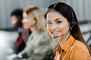 Selective focus of smiling female call center operator in headset