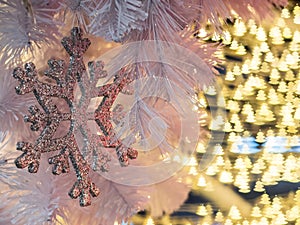 The selective focus of snowflake on with the background of yellow christmas tree shape bokeh along the wires of christmas