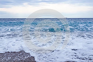 Selective focus Soft gentle waves with foam in blue ocean italy