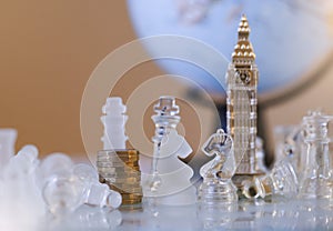 Selective focus of Stack new British one pound coins and souvenir of Big Ben tower with wood knight chess on board game in retro