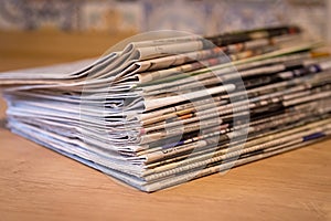 Selective focus of the stacking newspapers folded place on wooden table