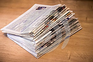 Selective focus of the stacking newspapers folded place on wooden table