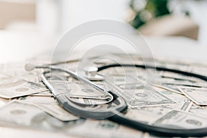 selective focus of stethoscope on dollar banknotes health