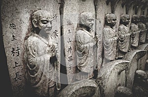Selective focus on stone buddhist statues in a line at the Daisho-in temple at Miyajima, Hiroshima, Japan