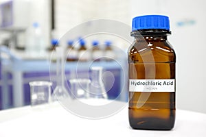 Selective focus of strong Hydrochloric acid solution in brown amber bottle. Blur laboratory backdrop with copy space.
