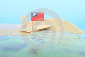 Selective focus of Taiwanese flag in blurry world map and wooden airplane model. Taiwan as travel and tourism destination concept.