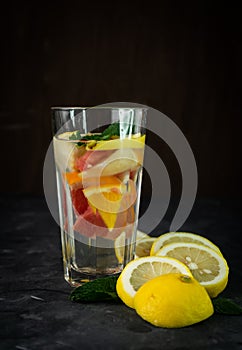 selective focus, a tall glass of water and citrus fruits