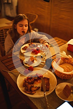 Selective focus. Teenage girl eating in the semi-darkness in a cafe.