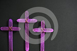 Selective focus of three purple wooden cross in black background. Holy week or lent season celebration concept.