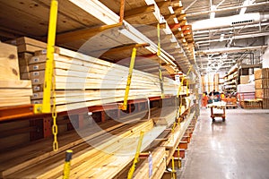 Selective focus timber shelves aisle with lumber cart, home improvement hardware store, chain link preventing warehouse rack