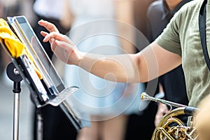 Selective focus to brass Instruments and wind instrument type with blurry a musician's hand is touching the screen o