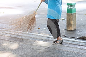 Selective focus to cleaning staff sweeping the floor with a broom