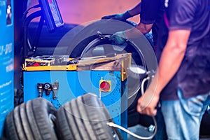 Selective focus to control panel of wheel balancer machine with blurry auto mechanic balances in the Car garage