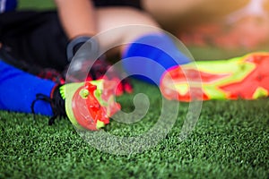 Selective focus to goalkeeper is sitting and catch the soles of the feet because of pain, soccer player was injured in the foot