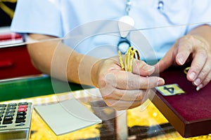 Selective focus to hand holding gold jewelry, customers are buying gold jewelry in the gold shop