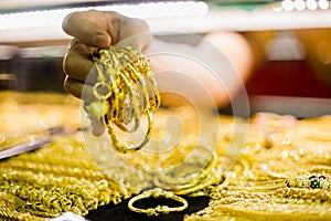 Selective focus to hand holding gold jewelry