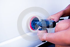 Selective focus to orbital polisher with hands in auto repair shop. Car detailing - Hands with orbital polisher