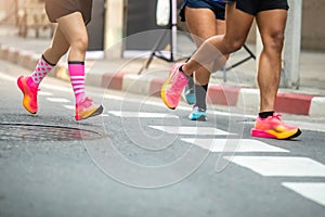 Selective focus to road surface with blurry human foot marathon race on city streets