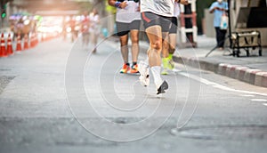 Selective focus to road surface with blurry human foot marathon race on city streets