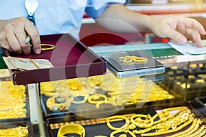 Selective focus to weighing gold jewelry with small digital scales in gold jewelry shop