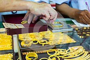 Selective focus to weighing gold jewelry with small digital scales in gold jewelry shop