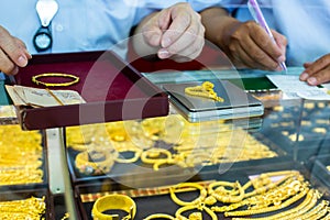 Selective focus to weighing gold jewelry with small digital scales in gold jewelry shop