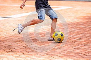 Selective focus to yellow ball with blurry futsal player playing