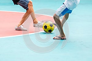 Selective focus to yellow ball with blurry futsal player playing