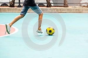 Selective focus to yellow ball with blurry futsal player playing