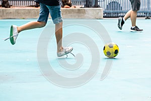 Selective focus to yellow ball with blurry futsal player playing