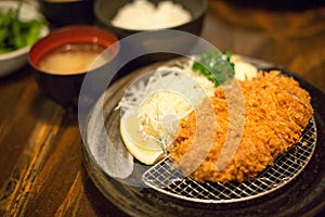 Selective focus of Tonkatsu set on wooden table in Japanese restaurant