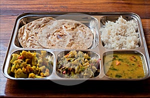 Selective focus on traditional Indian food. Bread chapati, vegetarian thali, daal, subji, rice