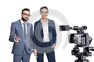 selective focus of two newscasters taking and looking at camera,