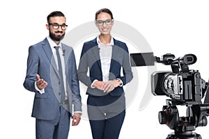 selective focus of two newscasters taking and looking at camera,