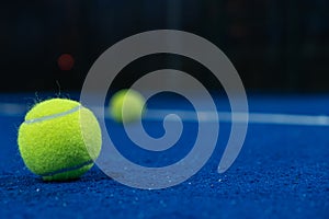 Selective focus. Two paddle tennis balls on the surface of a blue paddle tennis court
