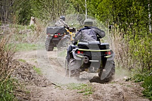 Selective focus. Two riders on ATVs ride on a dirt road. The concept of outdoor activities and extreme sports