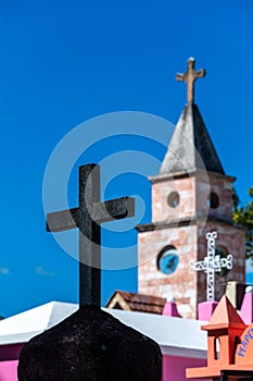 Selective focus vertical shot of a stone tombstone cross in a cemetery in Chiapas, Mexico