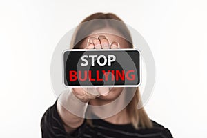 Selective focus of victim of cyberbullying showing smartphone with stop bullying lettering on screen isolated on white.