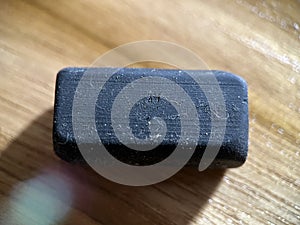 Black rubber eraser on wooden background photo