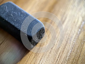 Black rubber eraser on wooden background photo