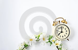 Selective focus vintage alarm clock  with beautiful bouquet flowers  on white background. Love anniversary, dating and present