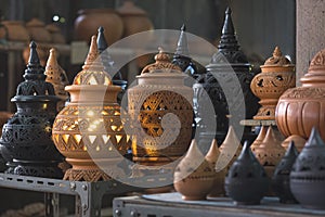 Selective focus at vintage clay electric lamp with various potteries on shelf display for sale in outdoor market