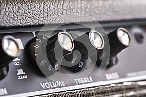 Selective focus of the volume, treble and bass control knobs of a guitar amplifier, equalization dials close up photo