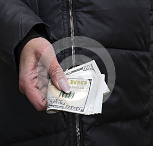 Selective focus.  A Wad of hundred dollar bills in female hand